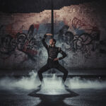 dancer under street lamp in rainy urban scene
